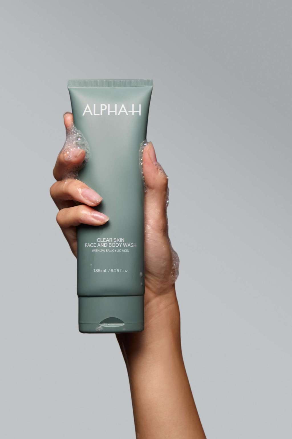 Alpha-H Clear Skin Face & Body Wash tube i hånden