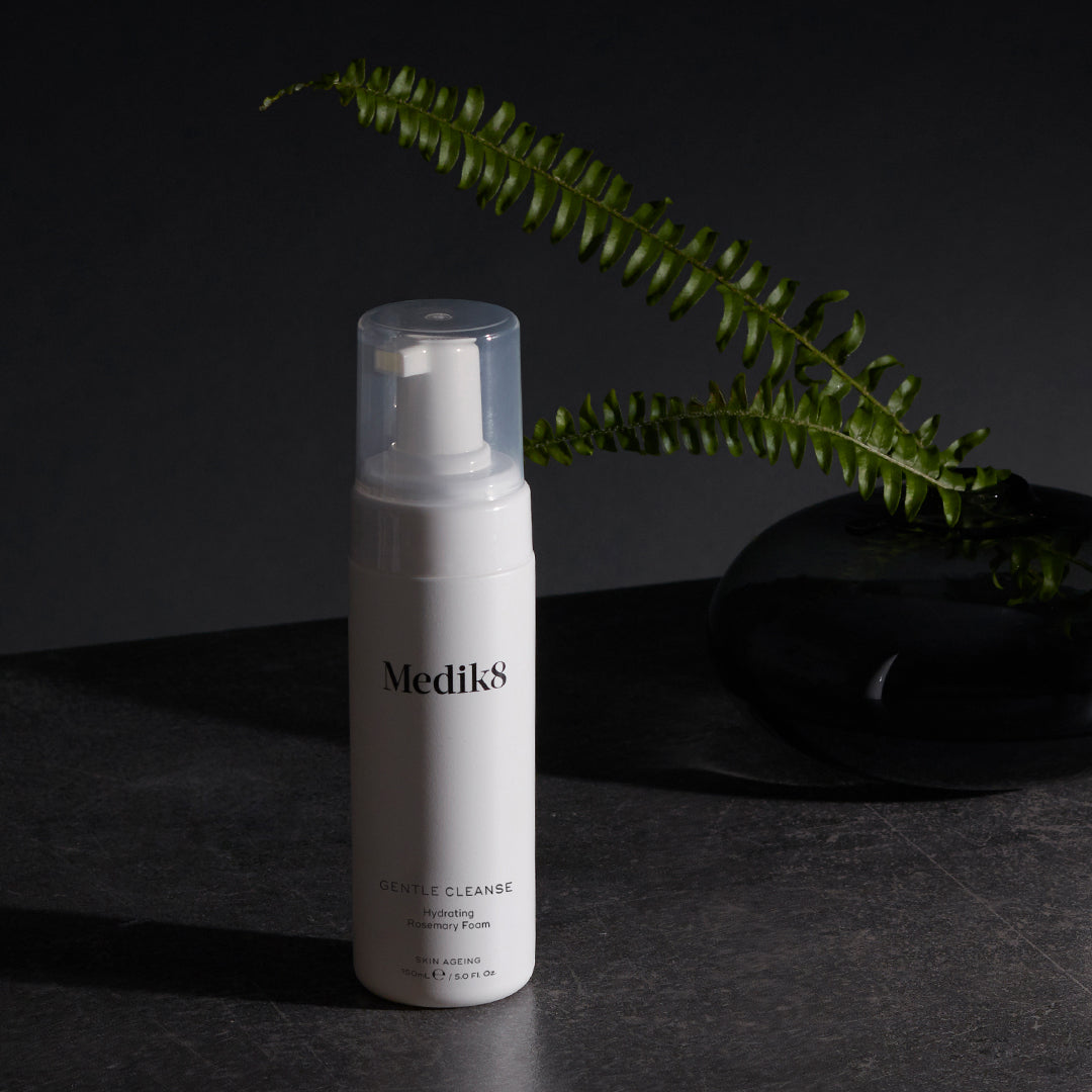Medik8 Gentle Cleanse flaske på mørk baggrund med bregne