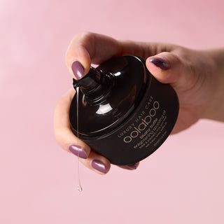 Oolaboo Blushy Truffle Sparkling Oil pumpe med oliedråbe i hånden