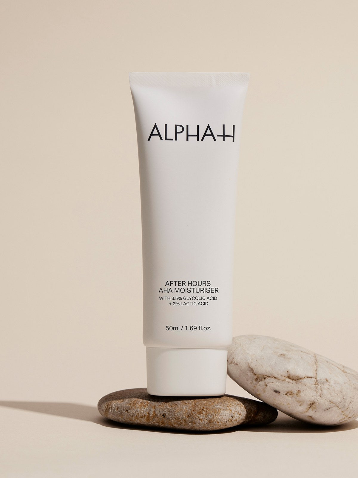 Alpha-H After Hours AHA Moisturiser på en stak sten