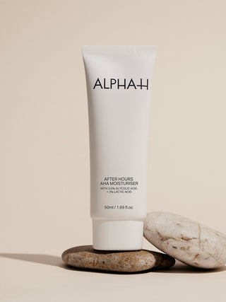 Alpha-H After Hours AHA Moisturiser på en stabel sten