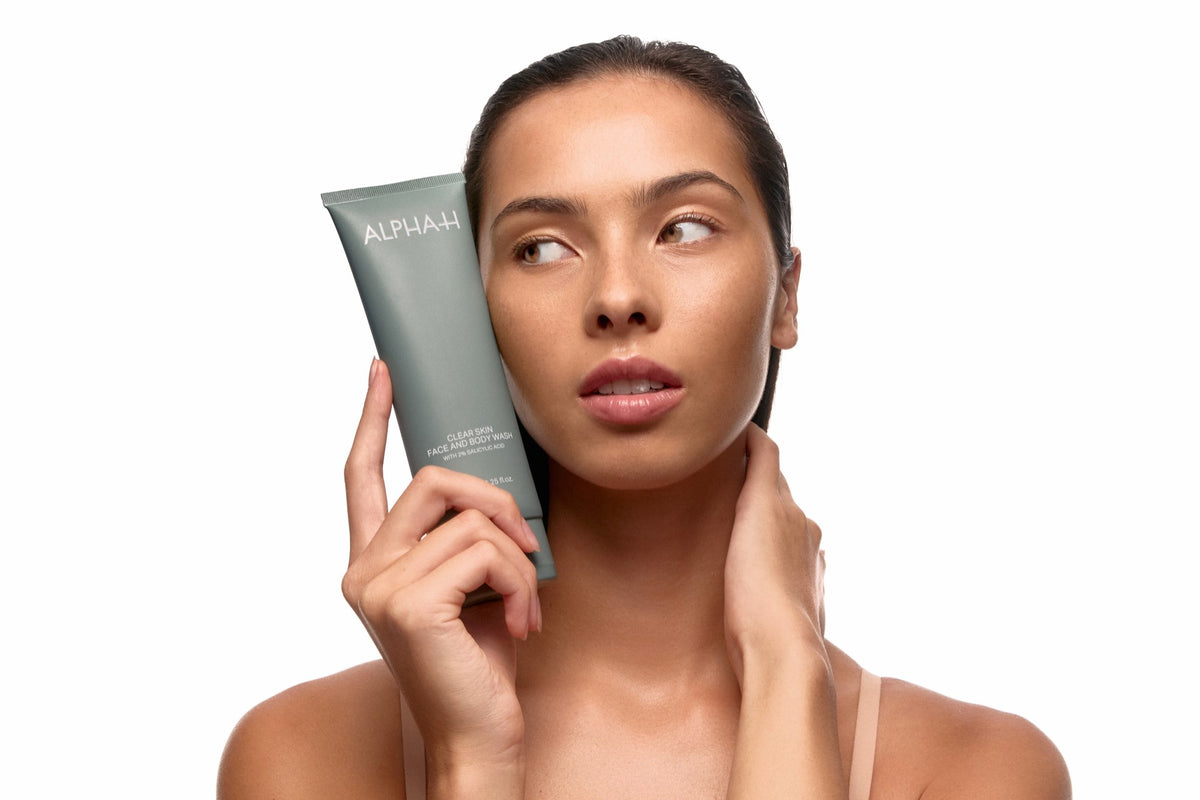 Alpha-H Clear Skin Face & Body Wash model med tube ved ansigtet