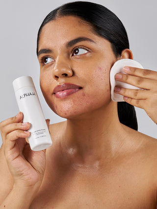 Alpha-H Clear Skin Tonic påføres med vatrondel