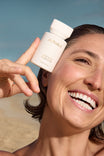 Alpha-H Liquid Gold Exfoliating Treatment model med flakon ved havet