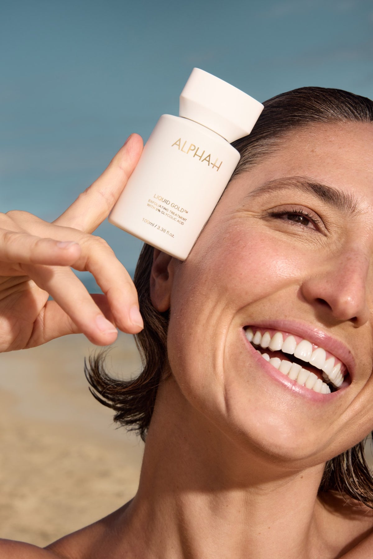 Alpha-H Liquid Gold Exfoliating Treatment model med flakon ved havet