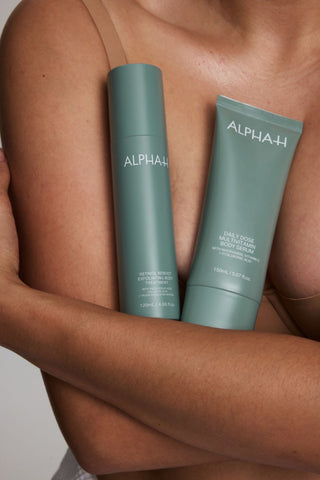 Alpha-H Retinol Reboot Exfoliating Body Treatment flaske mod armen