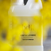 BDK Parfums Eau De Lessive Mimosa fles achter gele mimosatakjes