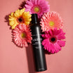 Oolaboo Glam Former Dry Shampoo mellem lyserøde gerberaer