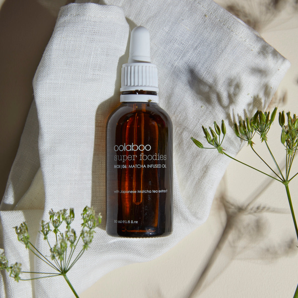 Oolaboo Super Foodies Matcha Infused Oil på hørklæde med blomster