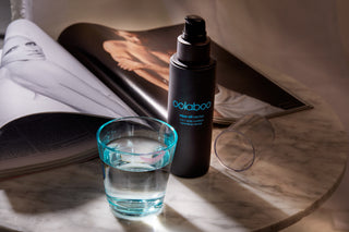 Oolaboo Wipe Off Nectar på marmor med et glas vand